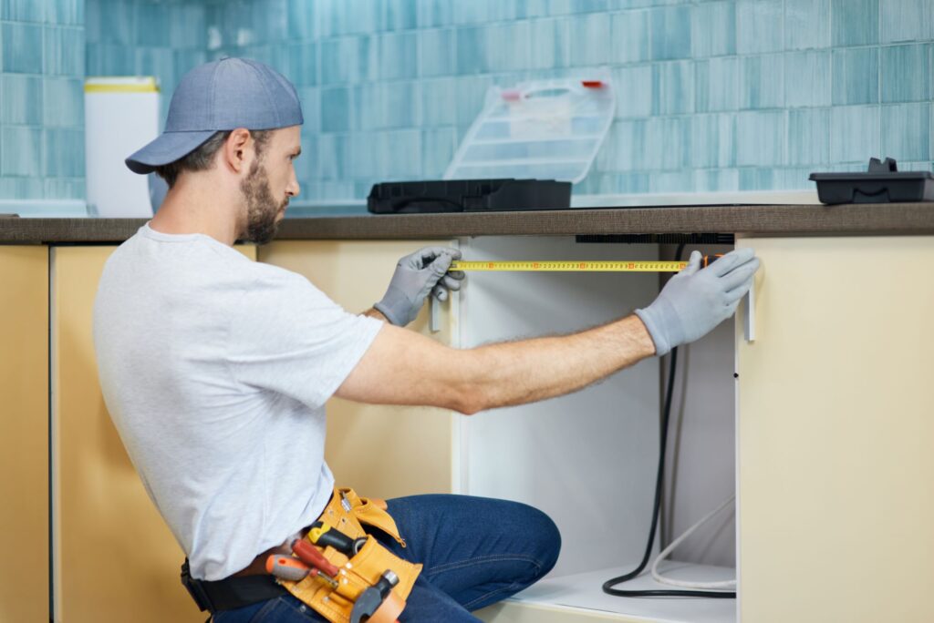 young repairman professional plumber using measure